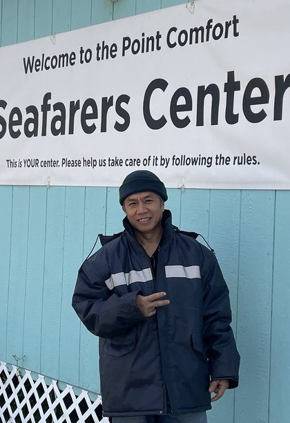A crew member giving a peace sign outside the Seafarers Center