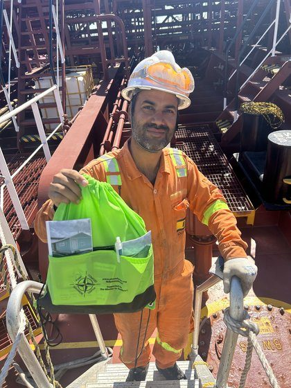 A crew member holding a welcome bag with photos of the center