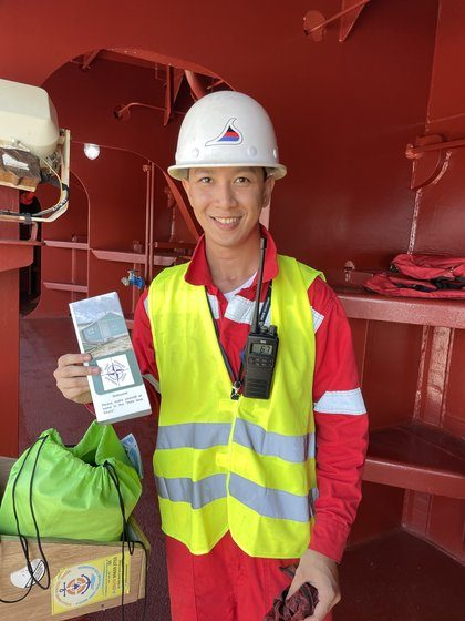 A crew member holding welcome cards on the gangway