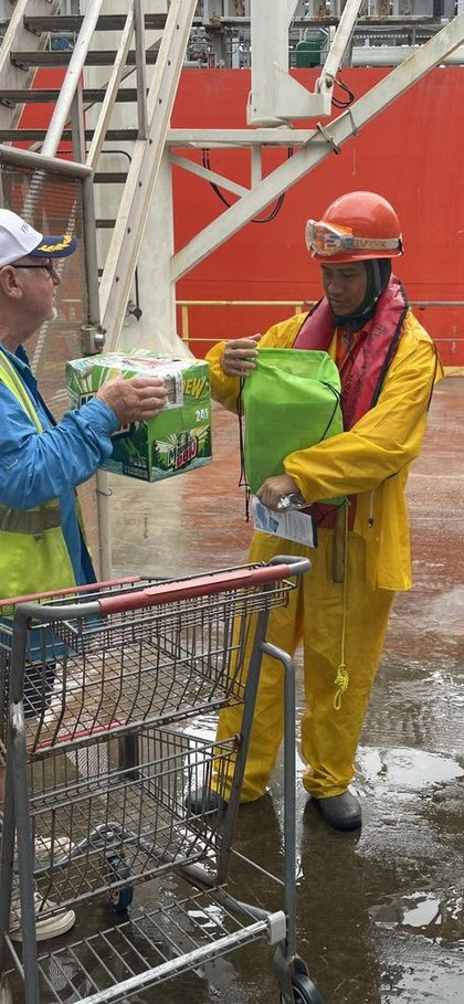A crew member with a bag of Doritos on the dock