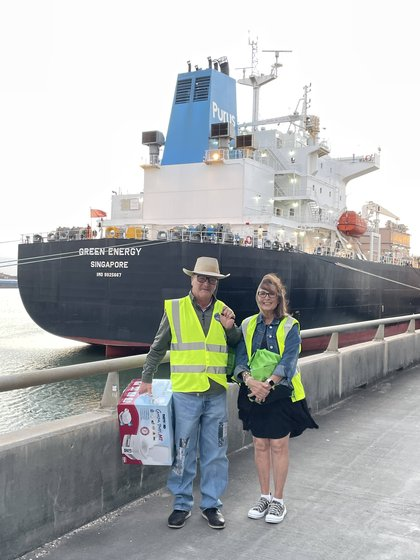 A couple posing with a gift box in front of the Green Energy tanker