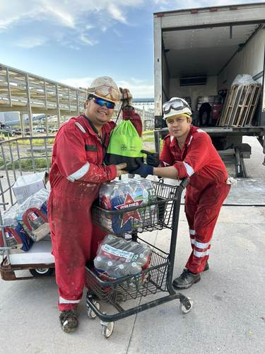 Volunteers loading a cart with water bottles for a ship visit