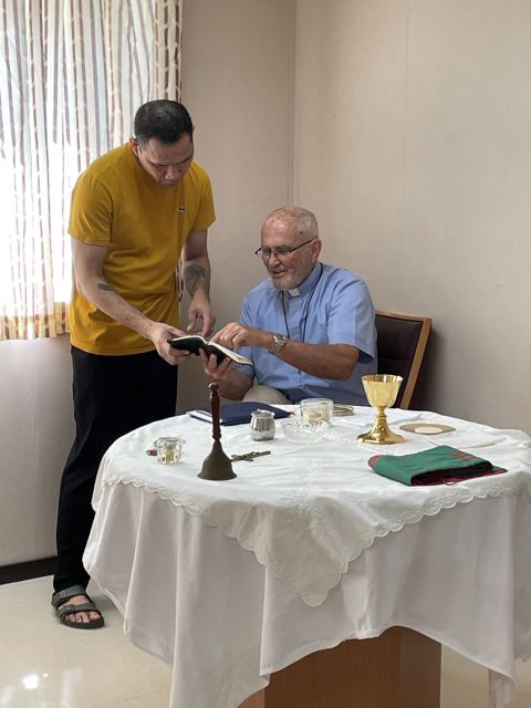 A priest sharing scripture with a crew member