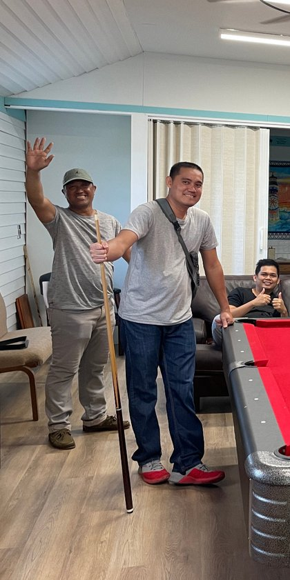 Two crew members playing pool at the center